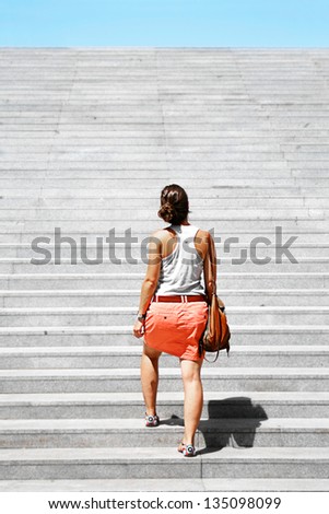 Young woman going upstairs. Challenge metaphor.