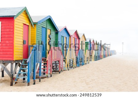 Multi-colored beach huts disappearing in the mist at Muizenberg in Cape Town, Western Cape Province of South Africa