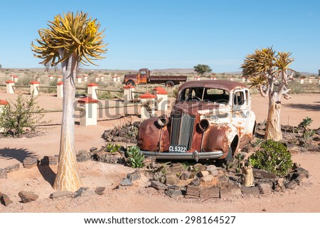FISH RIVER CANYON, NAMIBIA - JUNE 17, 2011: A rusted old car in a succulent garden between flowering quiver trees at a lodge near the Fish River Canyon