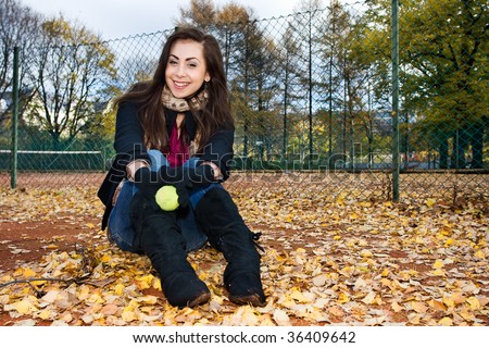 Portrait of a beautiful woman sitting in tennis court