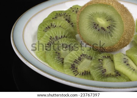 Kiwi fruit slices on saucer isolated on  black background