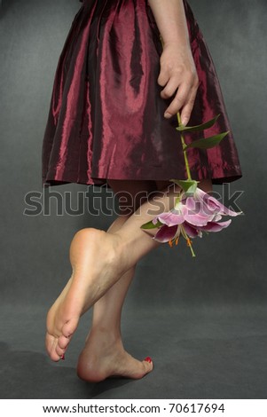 Woman legs with red satin dress over grey
