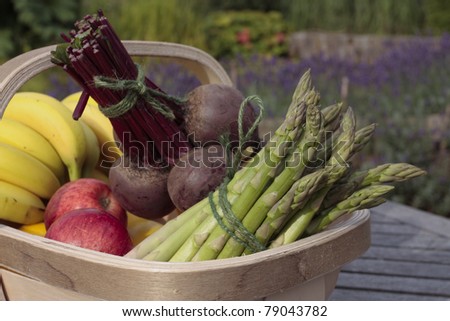 Mixed bunch of vegetables and fruit produce in basket outdoors