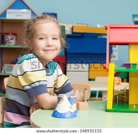 Child in kindergarten. Kids in nursery school. Girl playing at infant school. Game