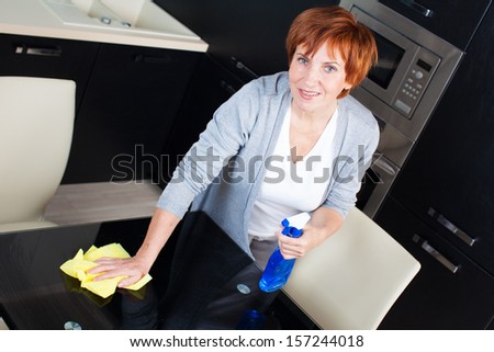 Woman cleaning the kitchen. Adult woman washing table