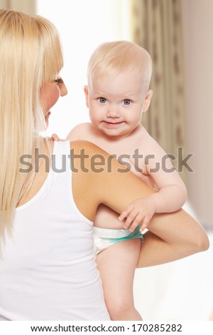 Mother with baby at home. Happy family with newborn indoors