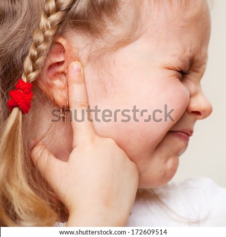 Child has a sore ear. Little girl suffering from otitis
