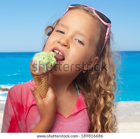 Child on the beach with ice cream. Girl at vacations on sea