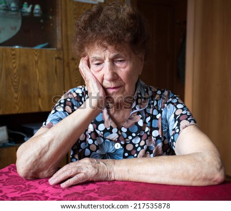 Old woman. Elderly sad female at home