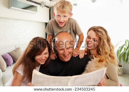 Family reads the newspaper at home