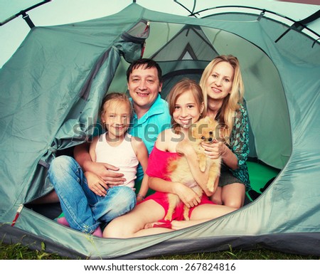 Family with children in a tent. Camping. Happy parents with kids at summer vacations