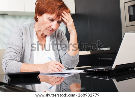 Sad businesswoman with document. Female sorting through her old receipts at home.