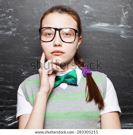 Girl near blackboard. Child at school. Thinking Student at classroom