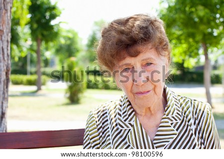 Old woman in park. Happy senior woman.