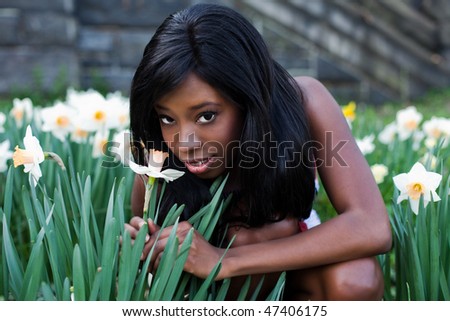 Black girl sitting in the field of narcissus