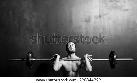 Bodybuilding, Young Athletic Strong Man Weightlifting , Black and White in studio