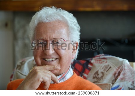 Portrait of an happy old man in his house