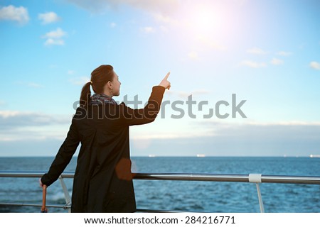 beautiful woman pointing at the sky