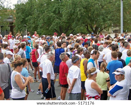 Photo of a group of runners at the start line waiting for the start signal of a road race.