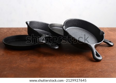 pile of cast iron skillets on old wood table ストックフォト © 