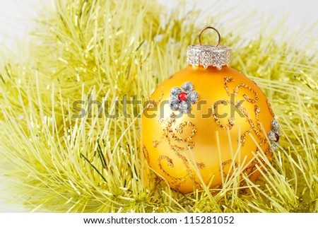 Yellow Christmas ball on a yellow tinsel