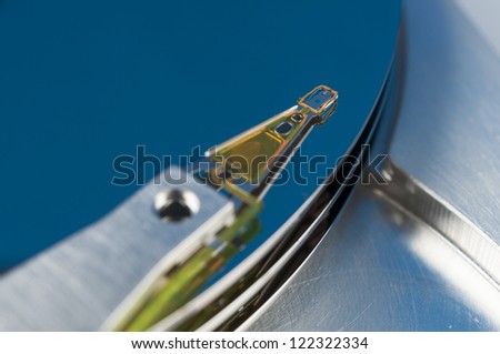 Hard disk read head closeup on a blue background