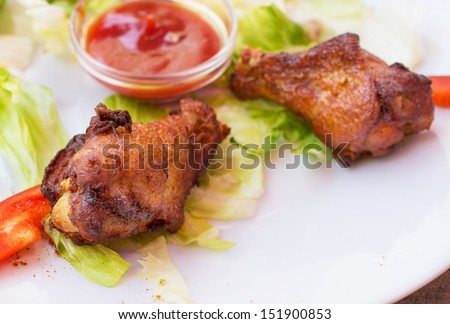 Hot meat dishes - grilled chicken wings with red spicy sauce