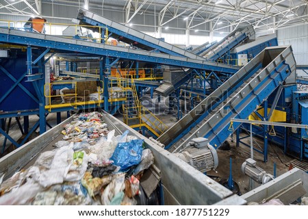 Waste sorting plant. Many different conveyors and bins. conveyors filled with various household waste.