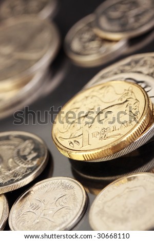 Various australian coins, focus on gold 1 dollar coin.
