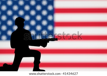 A lone toy soldier on an American flag background.