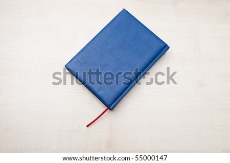 Blue leather diary book laying on wooden table