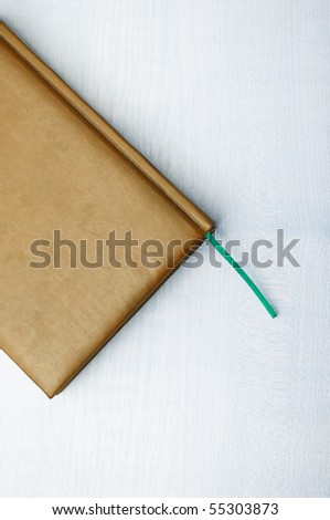 Detail of brown leather book laying on wooden table