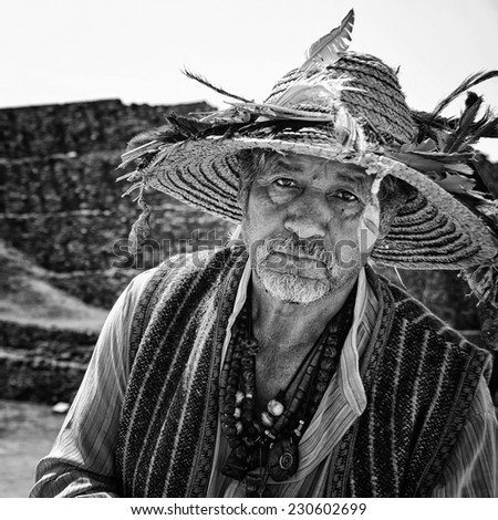 TULA, MEXICO - MARCH 15, 2011: Famous touristic site with Maya ruins and pyramids. Portrait of an old person in a traditional costume selling local souvenirs.