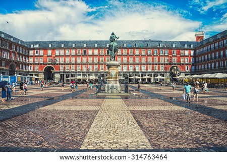MADRID, SPAIN - JULY 22, 2015: Plaza Mayor with people - a central square in the city. The bronze statue of King Philip III in the middle, created in 1616. Famous landmark, toning