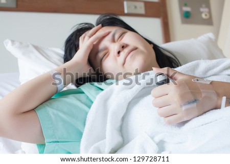 woman having headache and lying on bed with hand on head and Press the emergency button