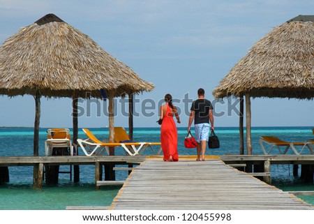 couple in romantic walk along tropical ocean pier