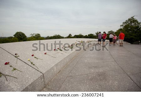 WASHINGTON D.C., MAY 26, 2014: Tourists leave flowers for fallen soldiers at Arlington National Cemetery during Memorial Day weekend on May 26, 2014.