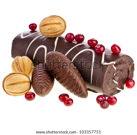 Chocolate swiss roll cake roulade with berries , nuts, cones isolated on white
