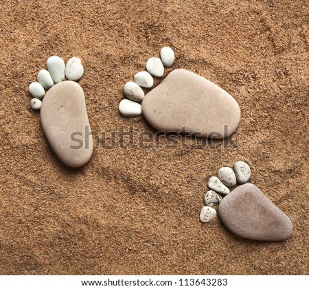 trace feet steps made of a pebble stone walking on the sea sand ,  pattern texture backdrop
