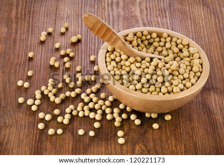 Soy beans in a wooden bowl on wooden desk texture