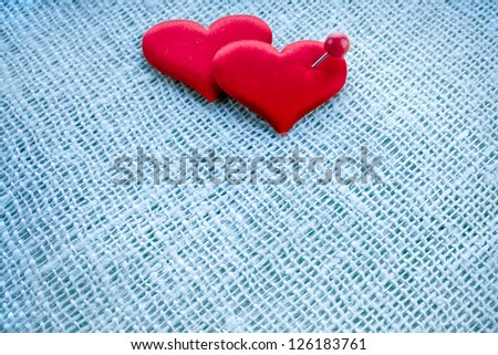 Valentine\'s day card,  red heart symbol with needle on fabric sack texture background