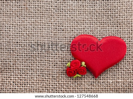 Valentine\'s day card with red heart symbol on fabric sack texture background