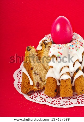 Easter bread cake with colored egg on red  background