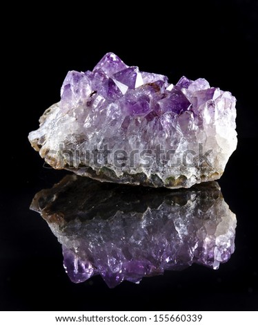 Natural cluster of Amethyst, violet variety of quartz close up macro with reflection on black surface background
