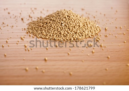 Dry yeast heap in wooden board table background