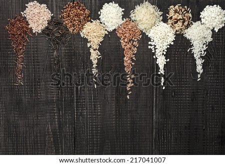 Border Frame made of colorful blend several varieties grain rice heap in a rustic wooden surface background