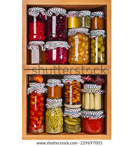 many glass bottles with preserved set food in wooden cabinet