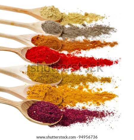 Assortment of powder spices on spoons isolated on a white background