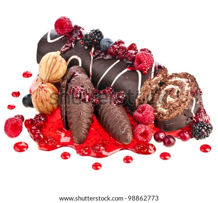 Chocolate swiss roll cake roulade  with berries , nuts, cones  isolated on white
