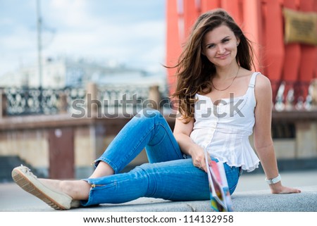 Outdoor portrait of young woman with fashion magazine
